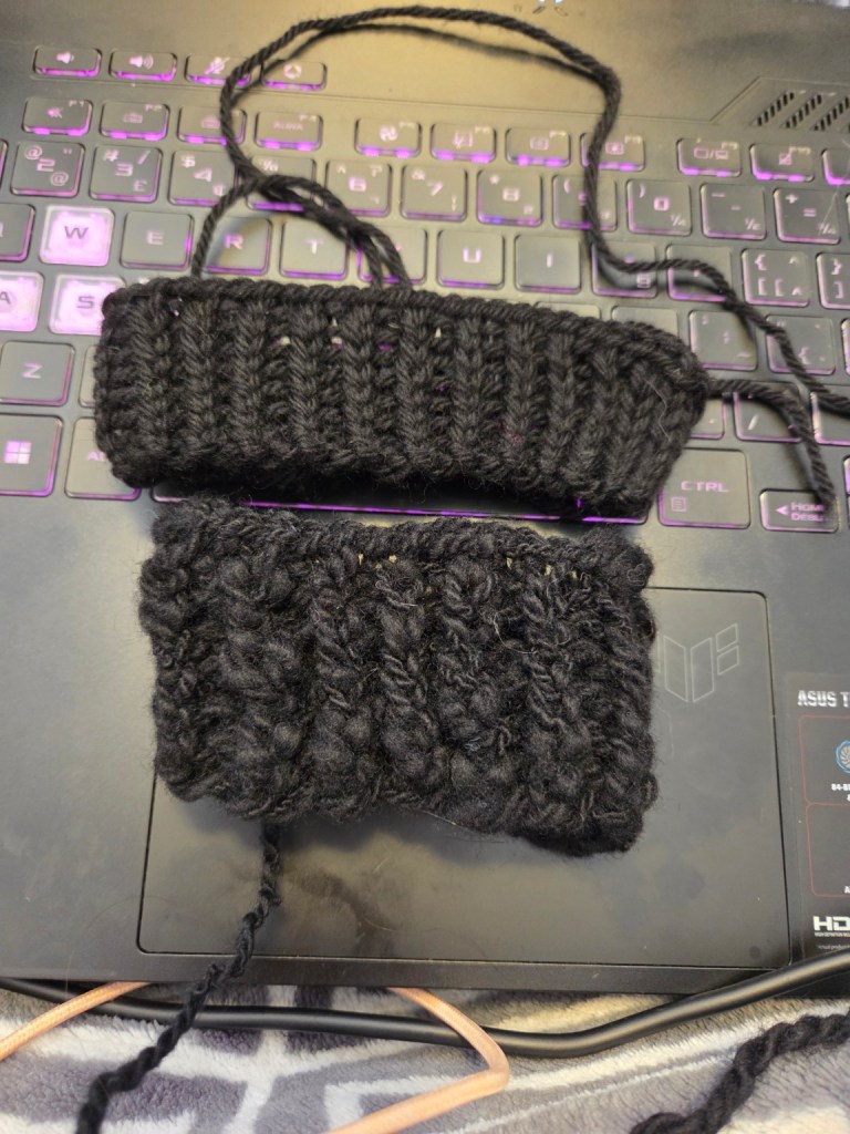 Two black knitted swatches on a laptop keyboard, one with twisted rib and the other with a textured stitch, illustrating different knitting techniques.